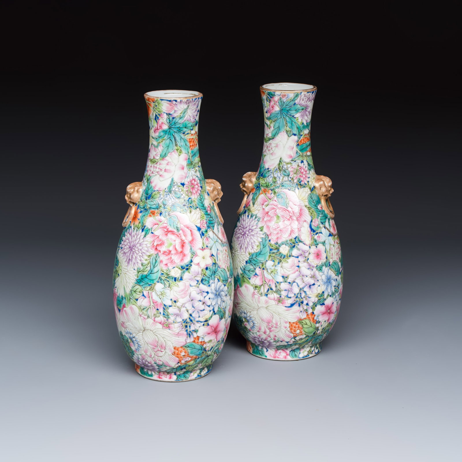 A pair of Chinese famille rose 'Millefleurs' vases with lion-head handles, Qianlong mark, Republic: A pair of Chinese famille rose 'Millefleurs' vases with lion-head handles, Qianlong mark, Republic H.: 25,4 cm