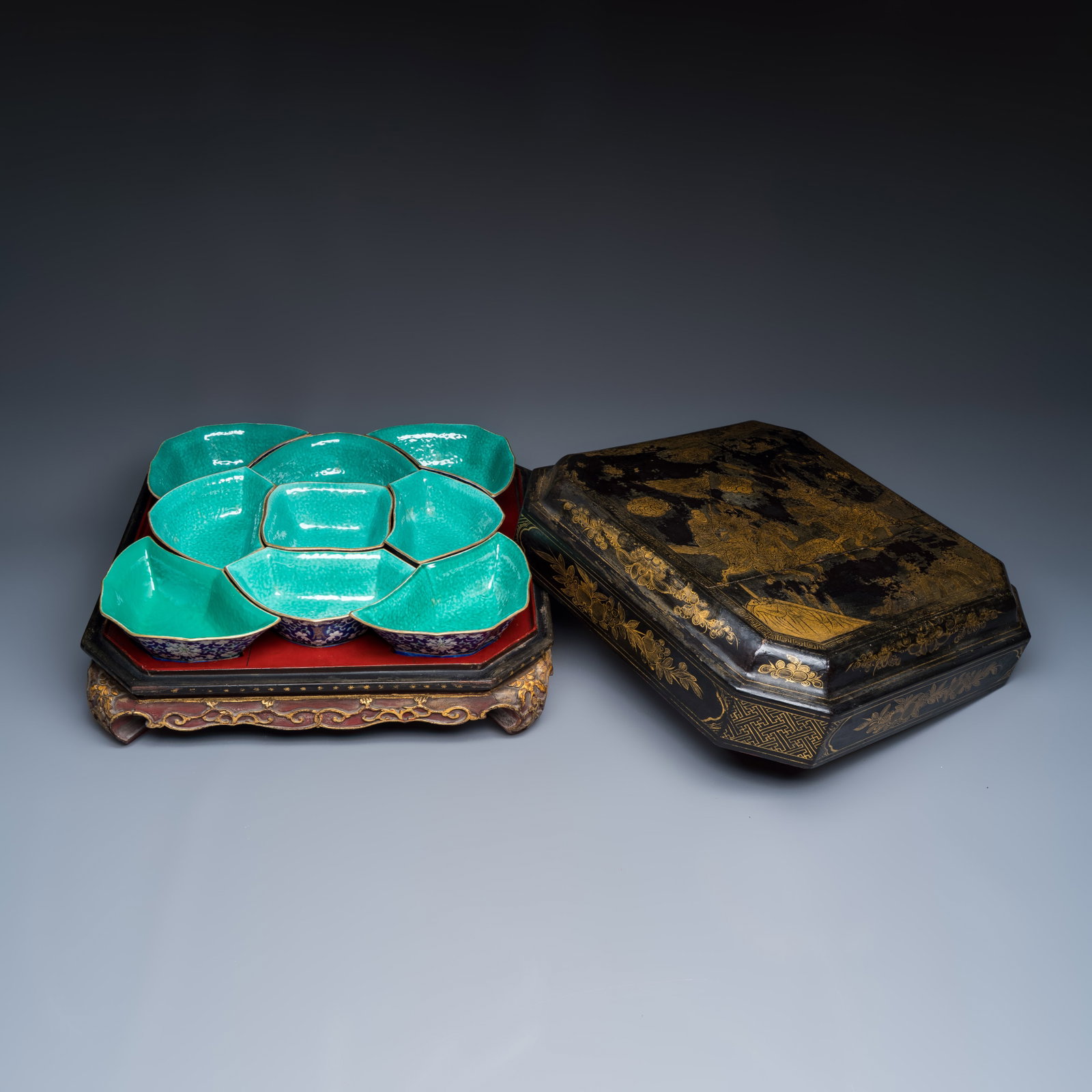 A Chinese polychrome-enamelled nine-piece sweetmeat set in a gilt-lacquered box, 19th C.: A Chinese polychrome-enamelled nine-piece sweetmeat set in a gilt-lacquered box, 19th C. Dim: 44,9 x 43,9 x 19,3 cm | the box, incl. cover Dim: 13,6 x 13,3 x 5,7 cm | the square bowl Dim: 19,4 x 12,8 