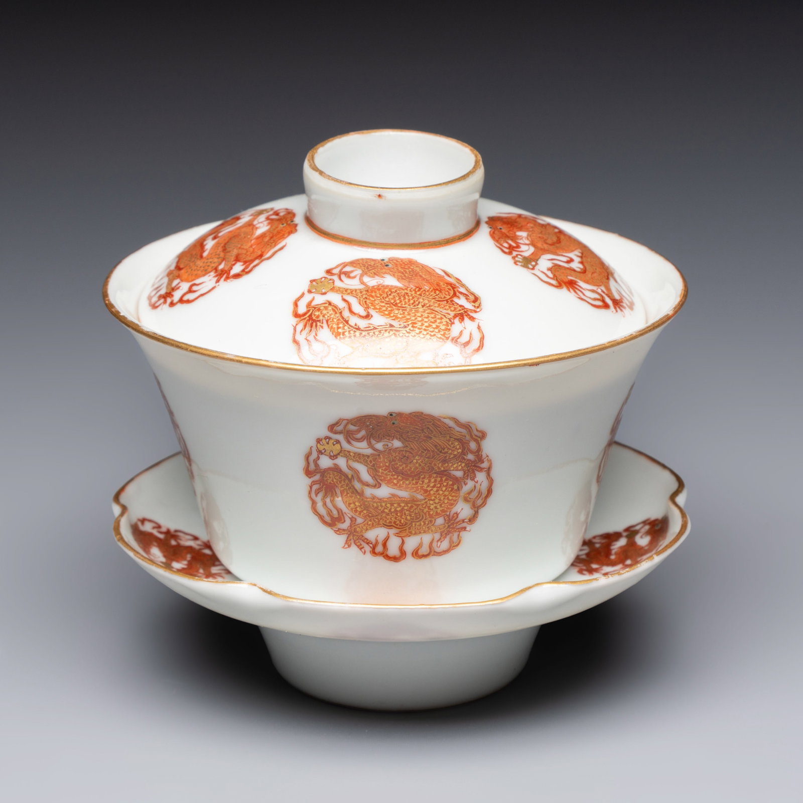 A fine Chinese iron-red and gilt-decorated 'Dragon' covered tea bowl with stand, Guangxu mark and of (1 of 12)