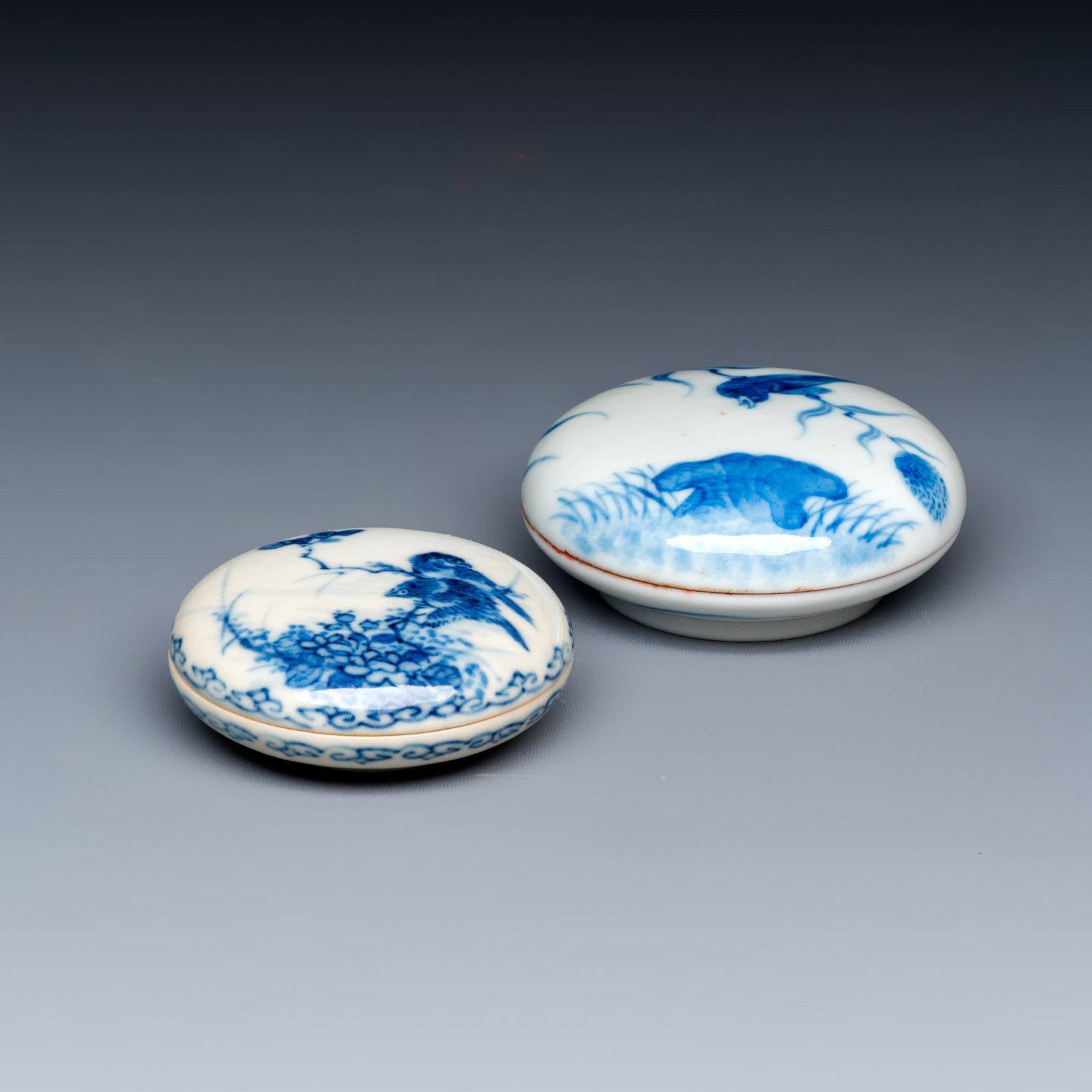 Two Chinese blue and white Wang Bu-style seal paste boxes and covers, Kangxi and Qianlong marks,: Two Chinese blue and white Wang Bu-style seal paste boxes and covers, Kangxi and Qianlong marks, 20th C. Dia.: 7,2 cm - H.: 3,1 cm | the largest, incl. cover Dia.: 6,2 cm - H.: 2,5 cm | the smallest, 