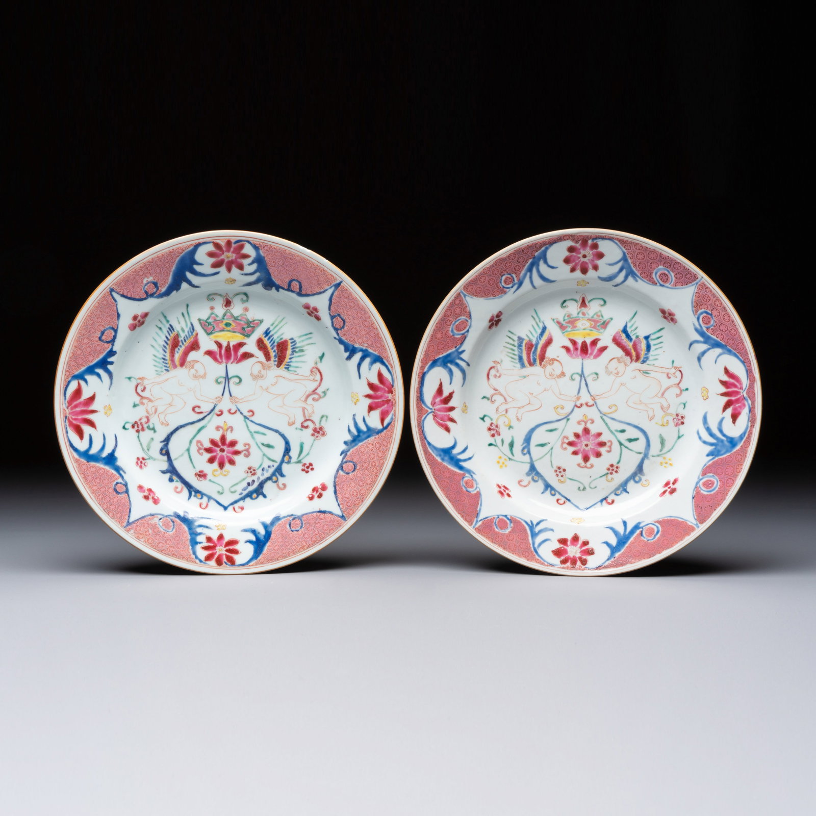 A pair of Chinese famille rose 'Winged Putti' plates, Yongzheng/Qianlong (1 of 2)