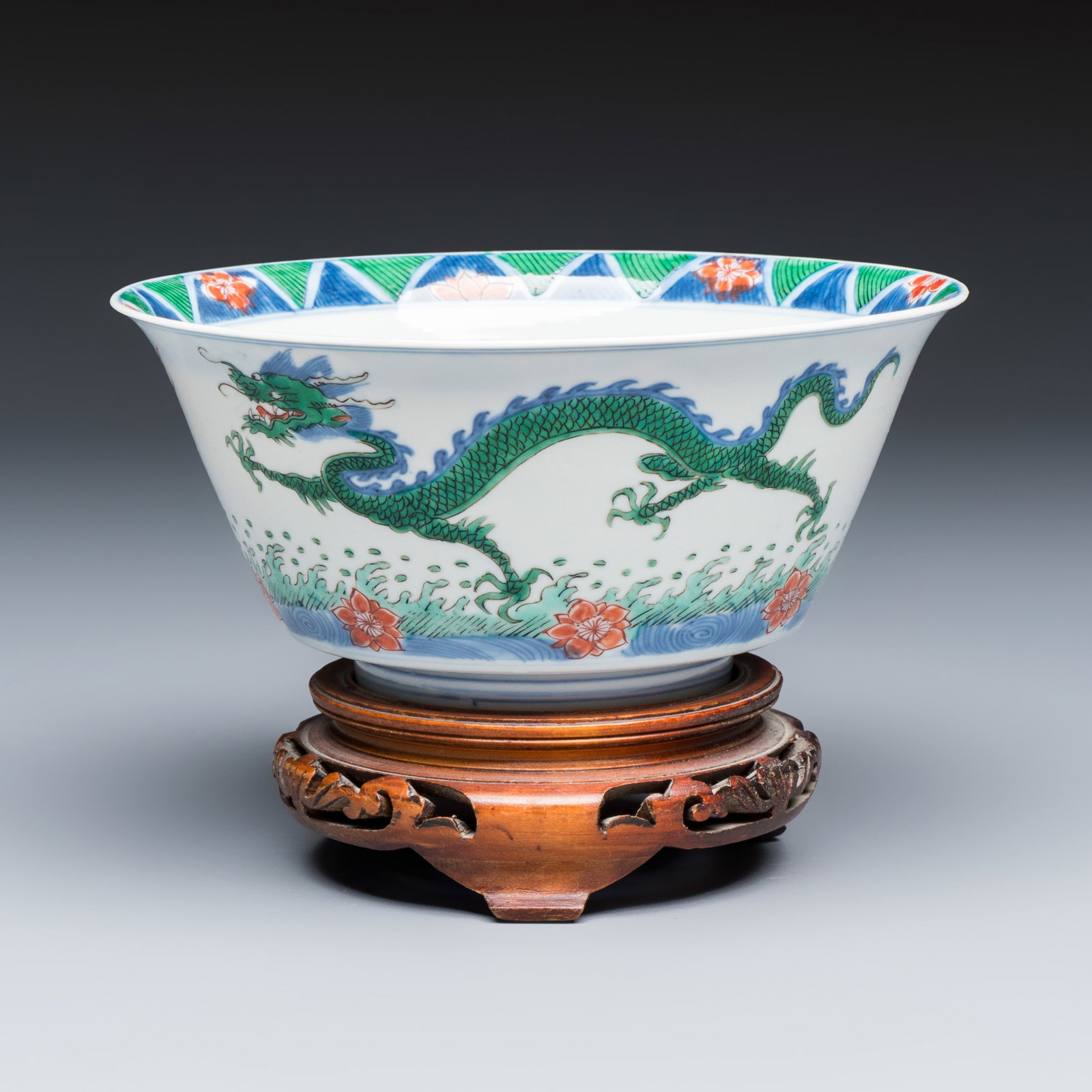 A Chinese famille verte 'Dragon' bowl on a later wooden stand, Kangxi mark and of the period: A Chinese famille verte 'Dragon' bowl on a later wooden stand, Kangxi mark and of the period Dia.: 15,5 cm - H.: 11 cm | incl. stand Dia.: 15,5 cm - H.: 7,5 cm | excl. stand