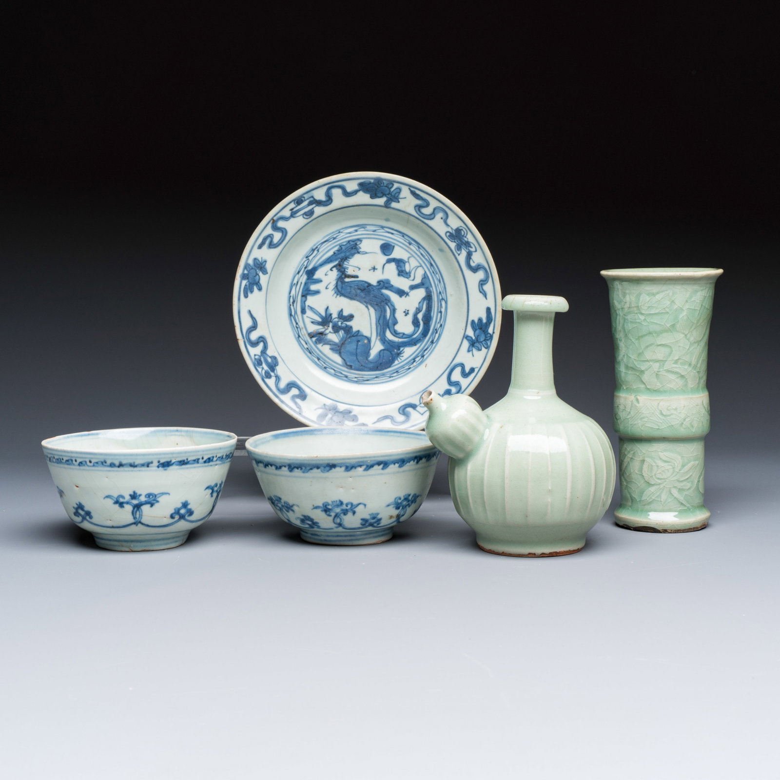 Two Chinese blue and white bowls, a plate, a celadon kendi and a vase, Ming: Two Chinese blue and white bowls, a plate, a celadon kendi and a vase, Ming L.: 12,5 cm - H.: 16,3 cm | the kendi H.: 17,5 cm | the vase Dia.: 13,2 cm - H.: 6,5 cm | the bowls Dia.: 19 cm | the plate
