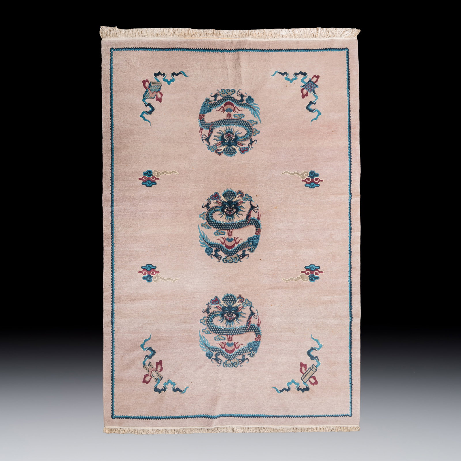 A large Chinese woollen pink-ground 'Dragon' carpet, 20th C. (1 of 2)