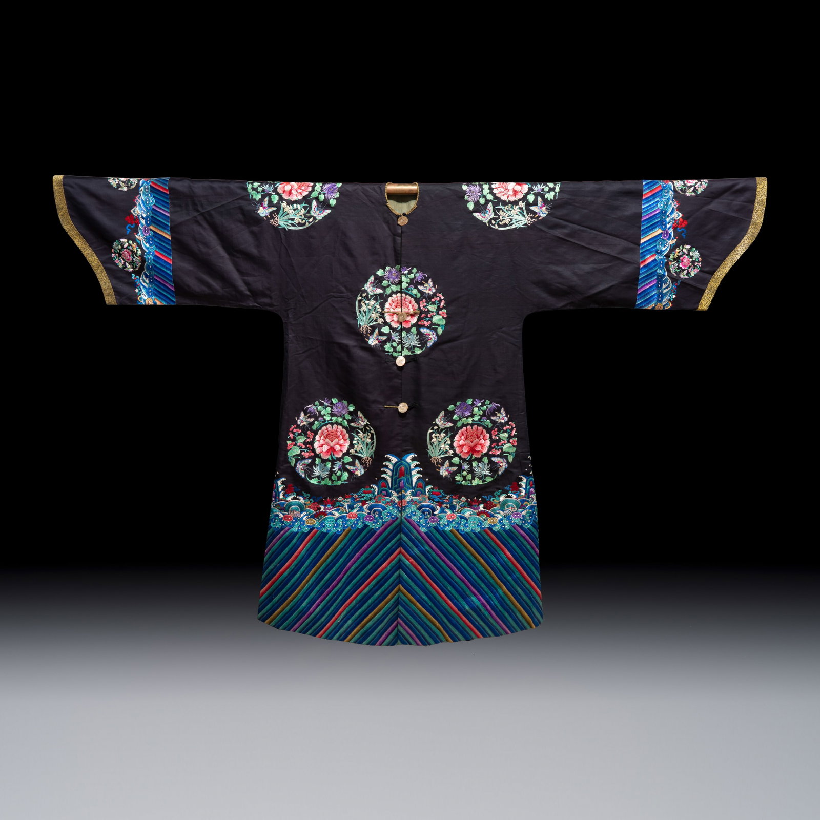 A Chinese embroidered silk dark-blue-ground robe with floral medallions, late Qing (1 of 2)