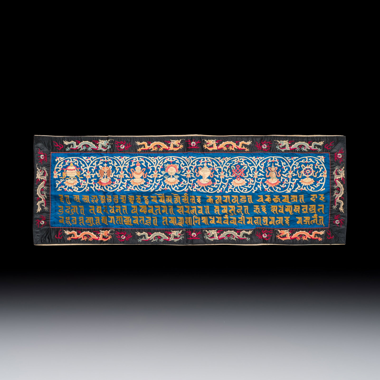 A Chinese embroidered silk panel with 'Eight Buddhist Emblems' and 'sutra', 19/20th C. (1 of 2)