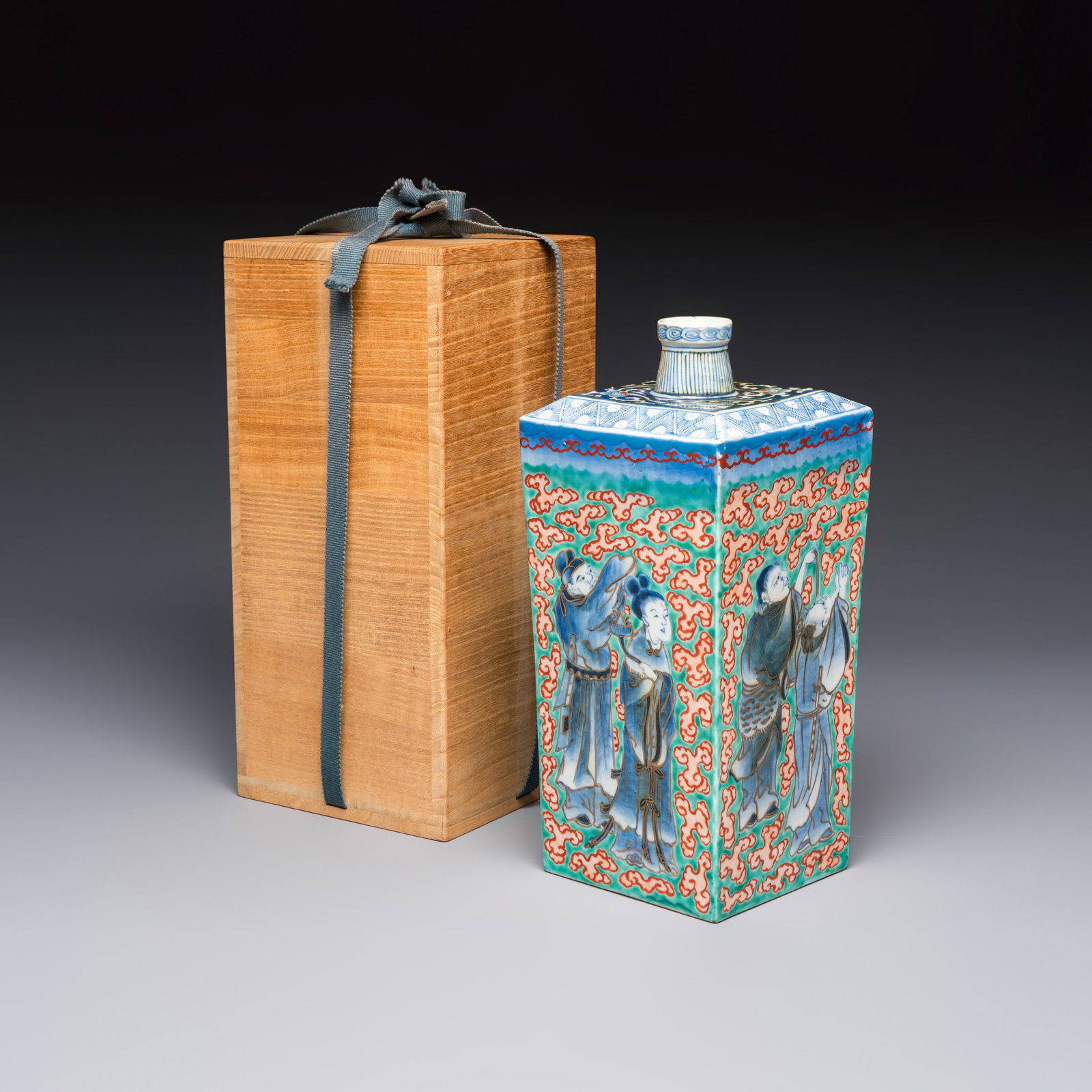 A Japanese Ko-Imari bottle with figural design, in a tomobako, Edo, ca. 1680-1710: A Japanese Ko-Imari bottle with figural design, in a tomobako, Edo, ca. 1680-1710 H.: 26,5 cm | the vase Dim: 13,7 x 13,7 x 29,4 cm | the box