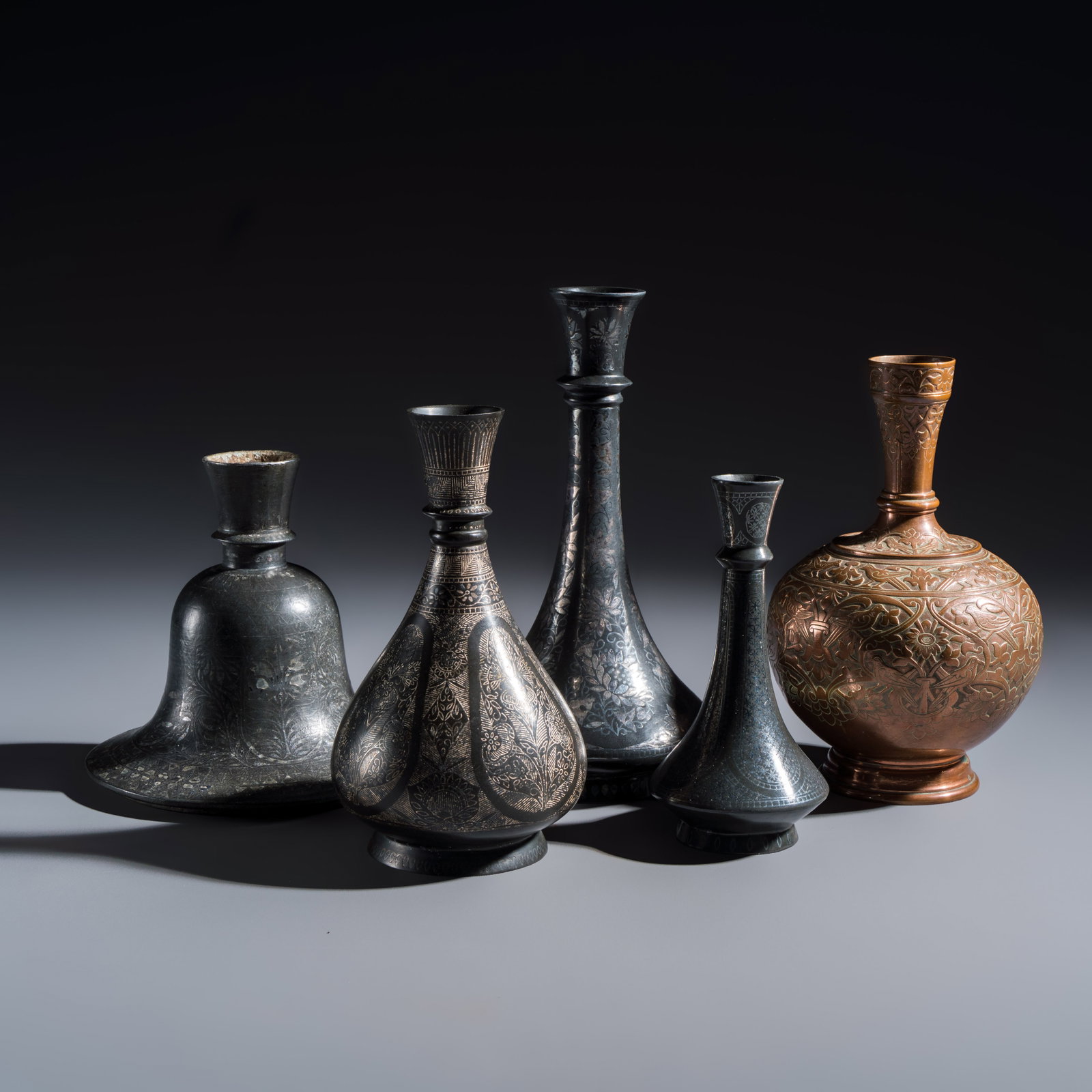 Four Bidri metal hookah bases and a copper hookah base or vase, Indian/Indo-Persian, 19th C. (1 of 13)