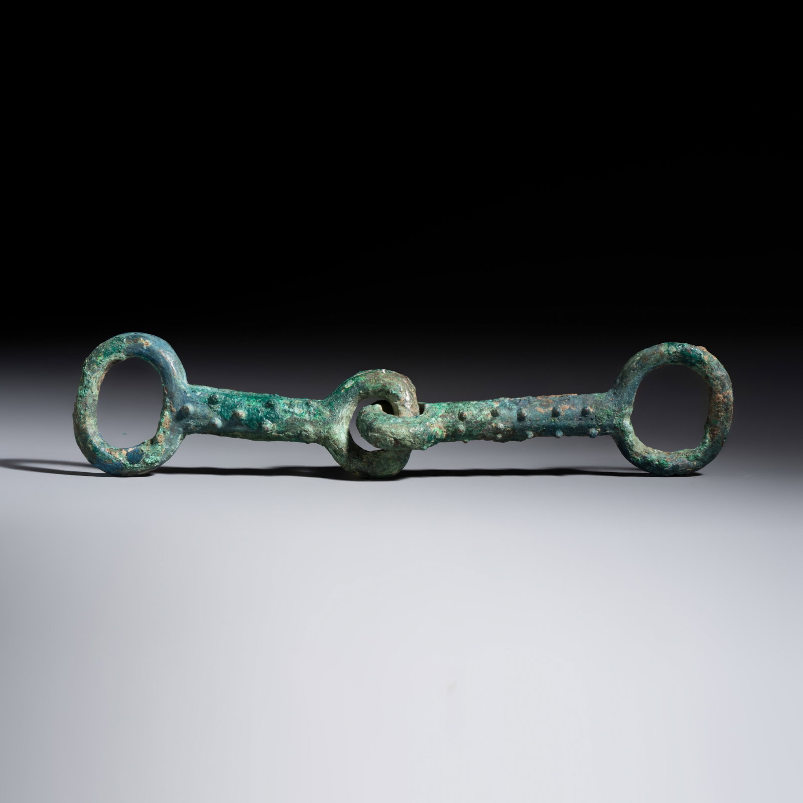 A Chinese archaic bronze horse bit, Eastern Zhou: A Chinese archaic bronze horse bit, Eastern Zhou Dim: 21,5 x 4,8 x 2,8 cm Weight: 285 grams