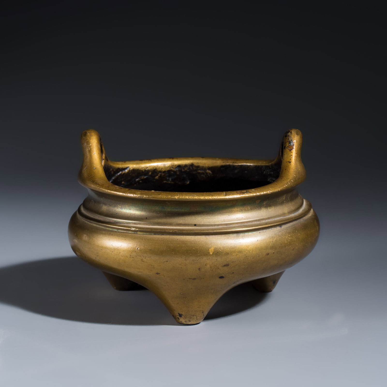 A Chinese bronze tripod censer with handles, Xuande mark, 19th C.: A Chinese bronze tripod censer with handles, Xuande mark, 19th C. L.: 13 cm - H.: 9,5 cm Weight: 1155 grams