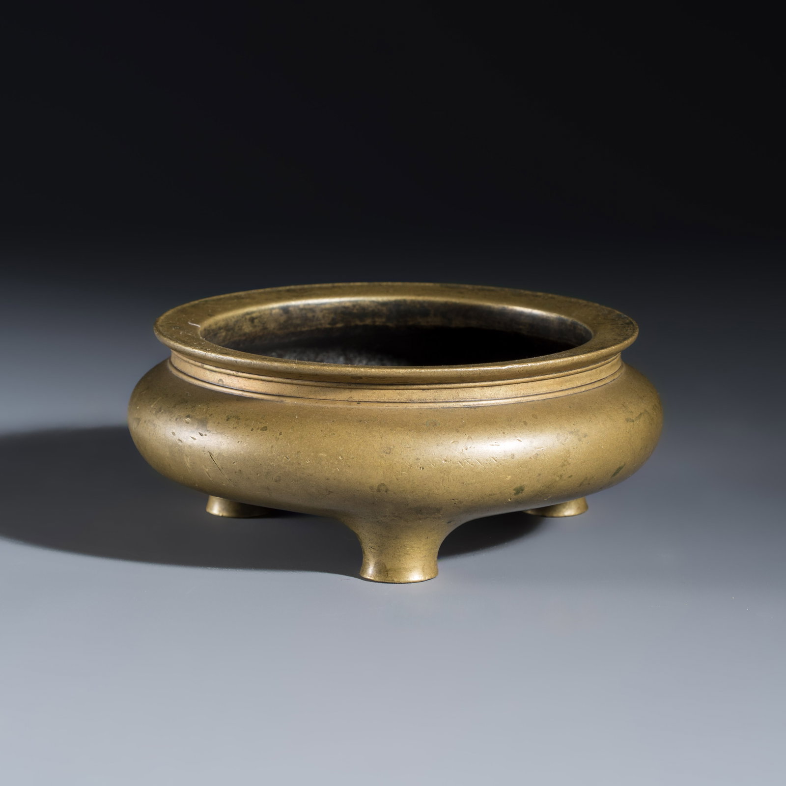 A Chinese bronze tripod censer, Xuande mark, 16/17th C.: A Chinese bronze tripod censer, Xuande mark, 16/17th C. Dia.: 14,5 cm - H.: 5,7 cm Weight: 1138 grams