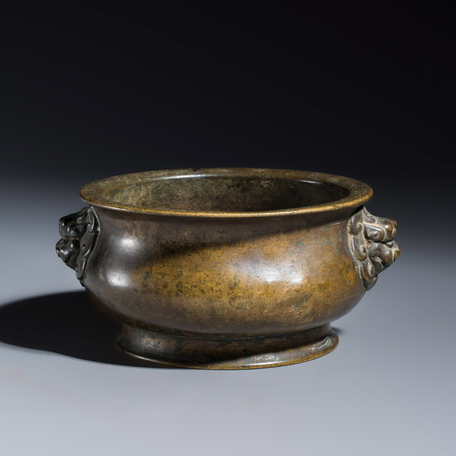 A Chinese bronze censer with lion-head handles, Xuande mark, 18th C.: A Chinese bronze censer with lion-head handles, Xuande mark, 18th C. L.: 16,1 cm - H.: 8,5 cm Weight: 908 grams Provenance: Bonhams London, 9-12 May 2022, lot 274. (sold GBP 3.187,50) A Dutch private 