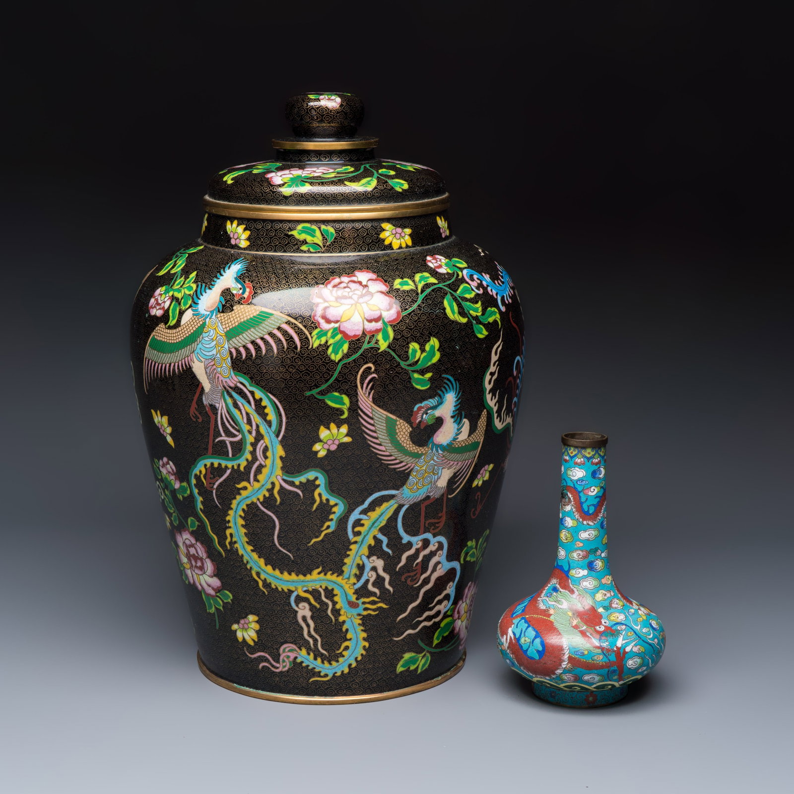 A Chinese cloisonne 'Phoenixes and Peonies' covered vase and a 'Dragons' bottle vase, 19/20th C.: A Chinese cloisonne 'Phoenixes and Peonies' covered vase and a 'Dragons' bottle vase, 19/20th C. H.: 44,9 cm | the tallest, incl. cover H.: 20,2 cm | the smallest