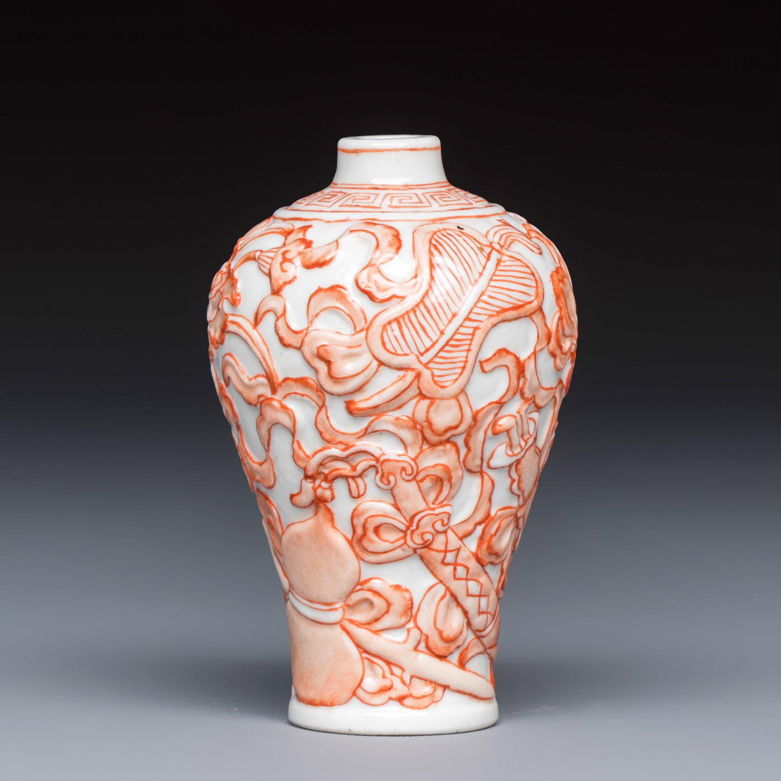 A Chinese iron-red-decorated relief-moulded 'An Ba Xian' snuff bottle, Daoguang mark, 19/20th C. (1 of 6)