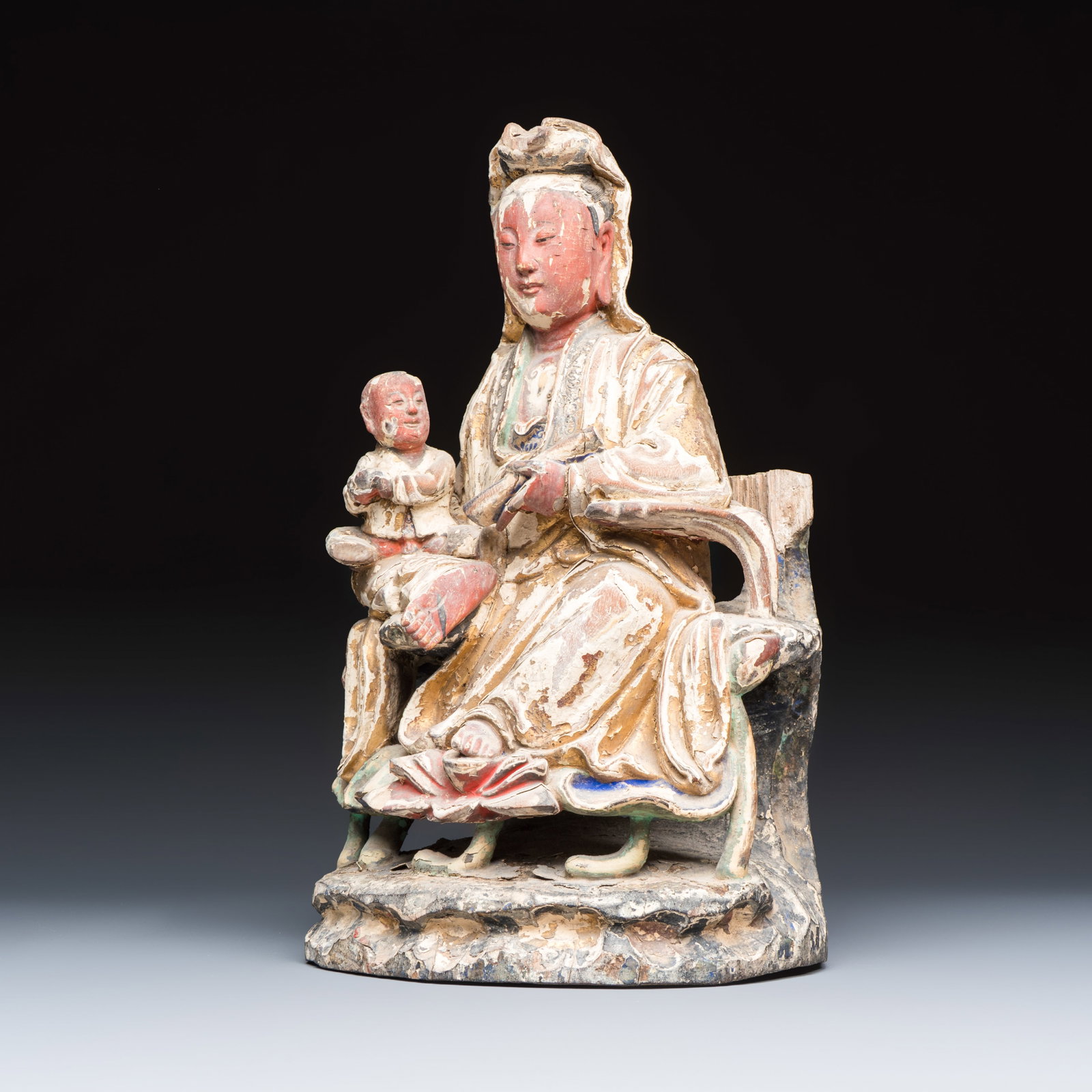 A Chinese gilt-polychromed carved wooden group of Guanyin and child, Qing: A Chinese gilt-polychromed carved wooden group of Guanyin and child, Qing H.: 29,6 cm