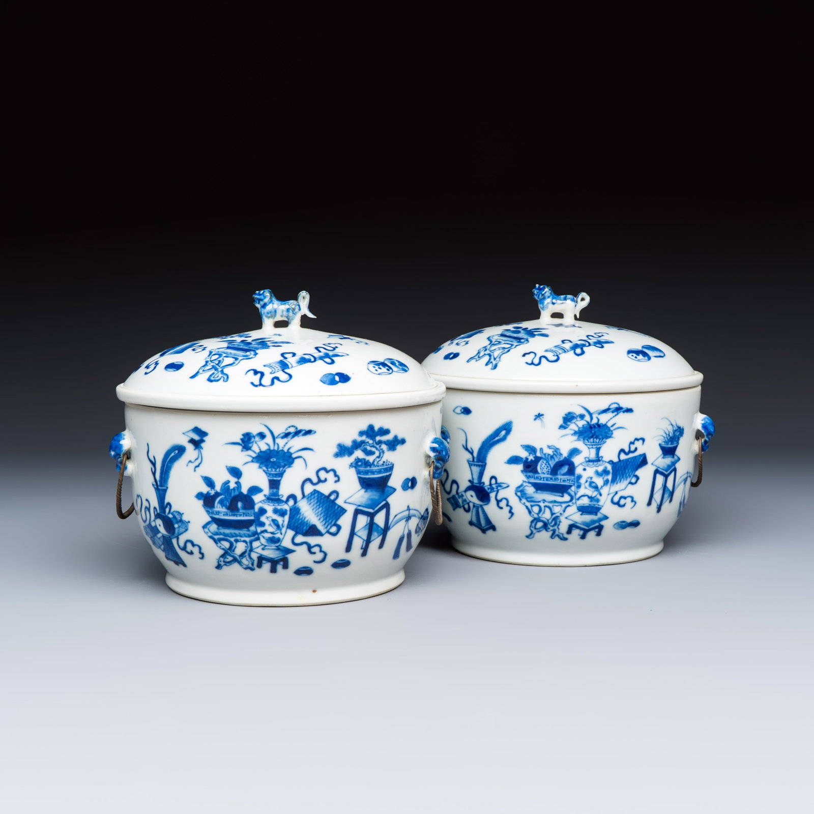 A pair of Chinese blue and white 'Antiquities' warming bowls with covers, 19th C.: A pair of Chinese blue and white 'Antiquities' warming bowls with covers, 19th C. L.: 19 cm - H.: 16,2 cm | incl. cover