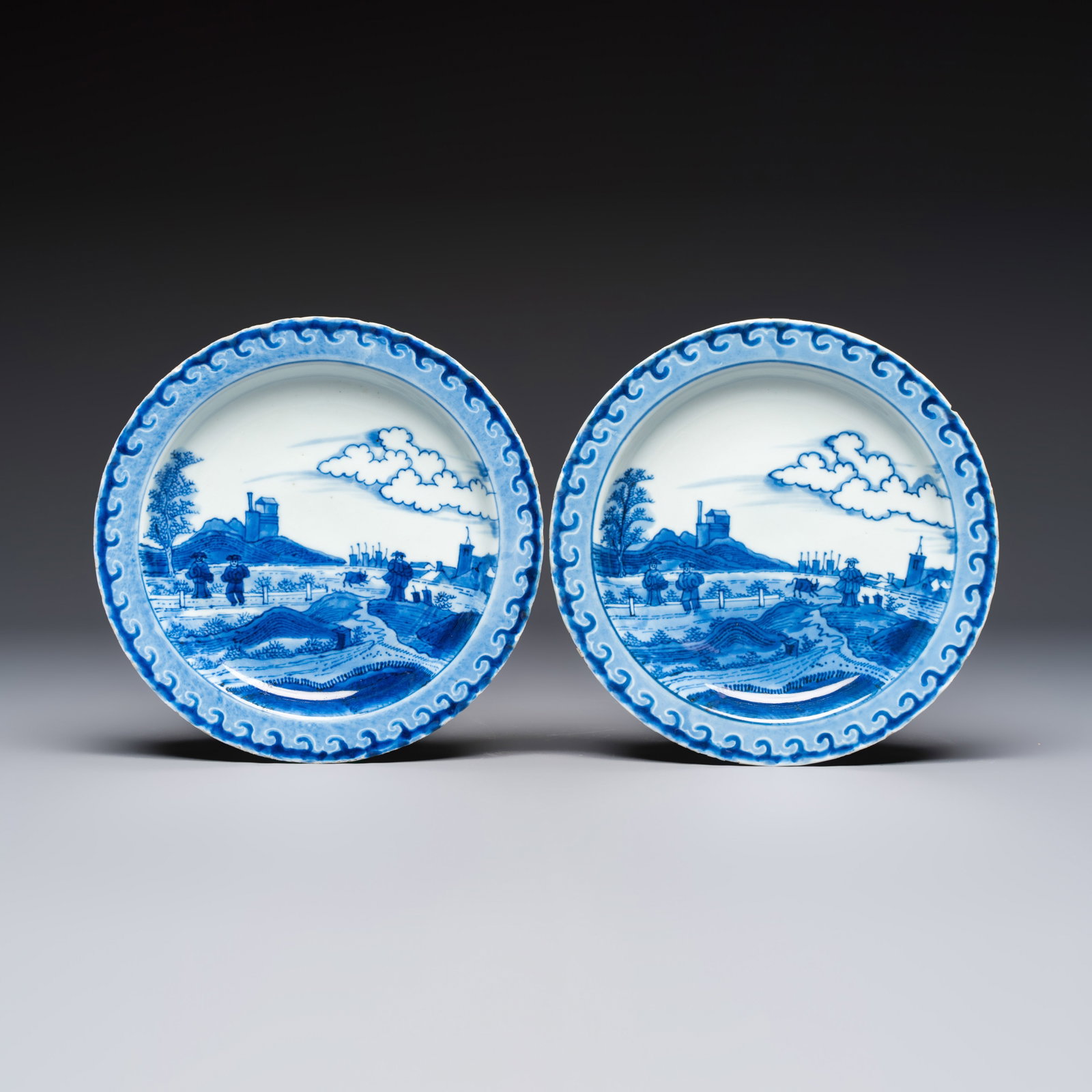 A pair of Chinese blue and white 'Scheveningen' or 'Nabeshima' plates, Kangxi/Yongzheng: A pair of Chinese blue and white 'Scheveningen' or 'Nabeshima' plates, Kangxi/Yongzheng Dia.: 19,5 cm Decorated in underglaze blue with a Dutch coastal landscape traditionally known as the ‘Scheveni