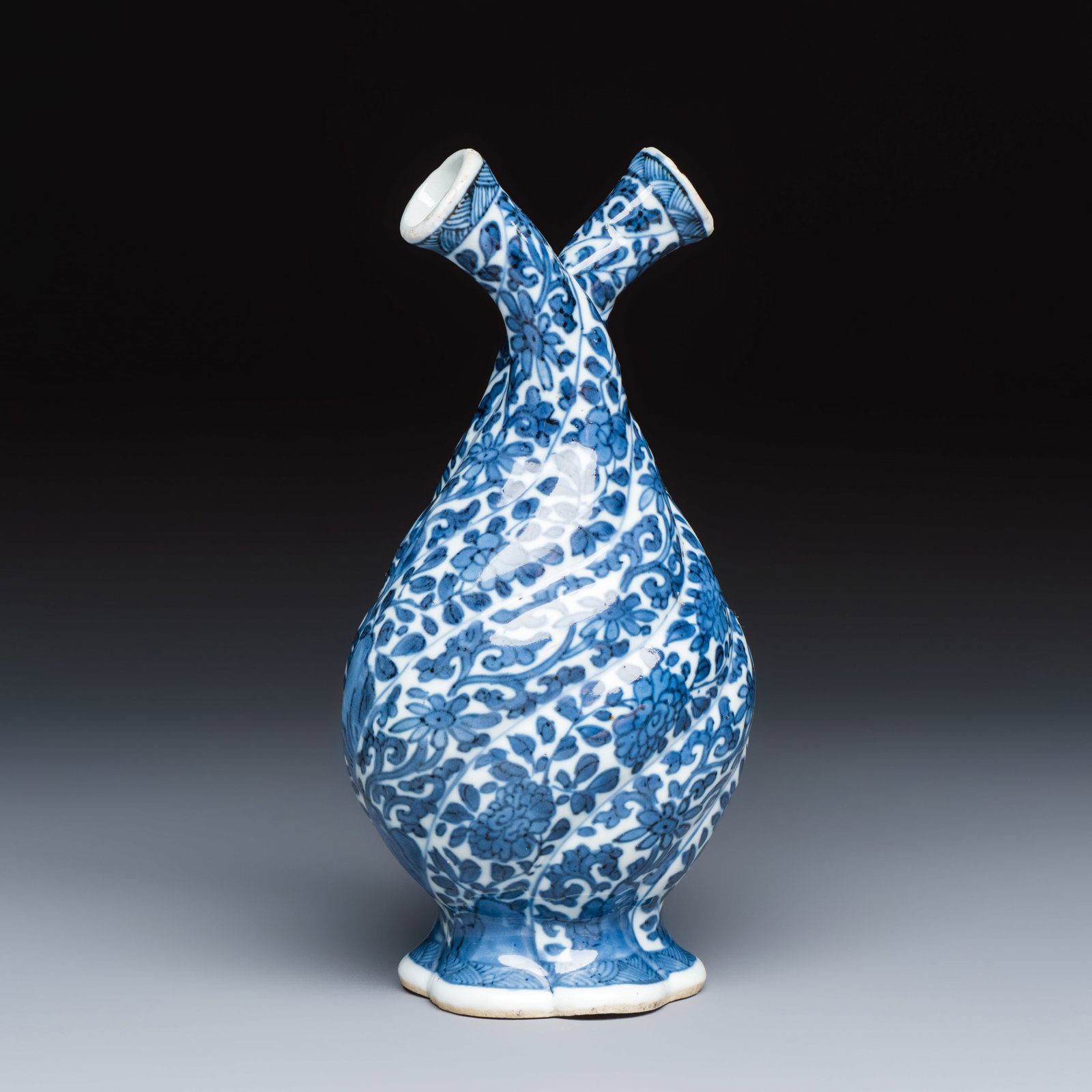 A Chinese blue and white double-spouted swirling-lobed cruet, artemisia leaf mark, Kangxi: A Chinese blue and white double-spouted swirling-lobed cruet, artemisia leaf mark, Kangxi H.: 19 cm Ref.: - Rob Michiels Auctions, 13 March 2021, lot 534 for a related example. (sold EUR 3.120,00) - T