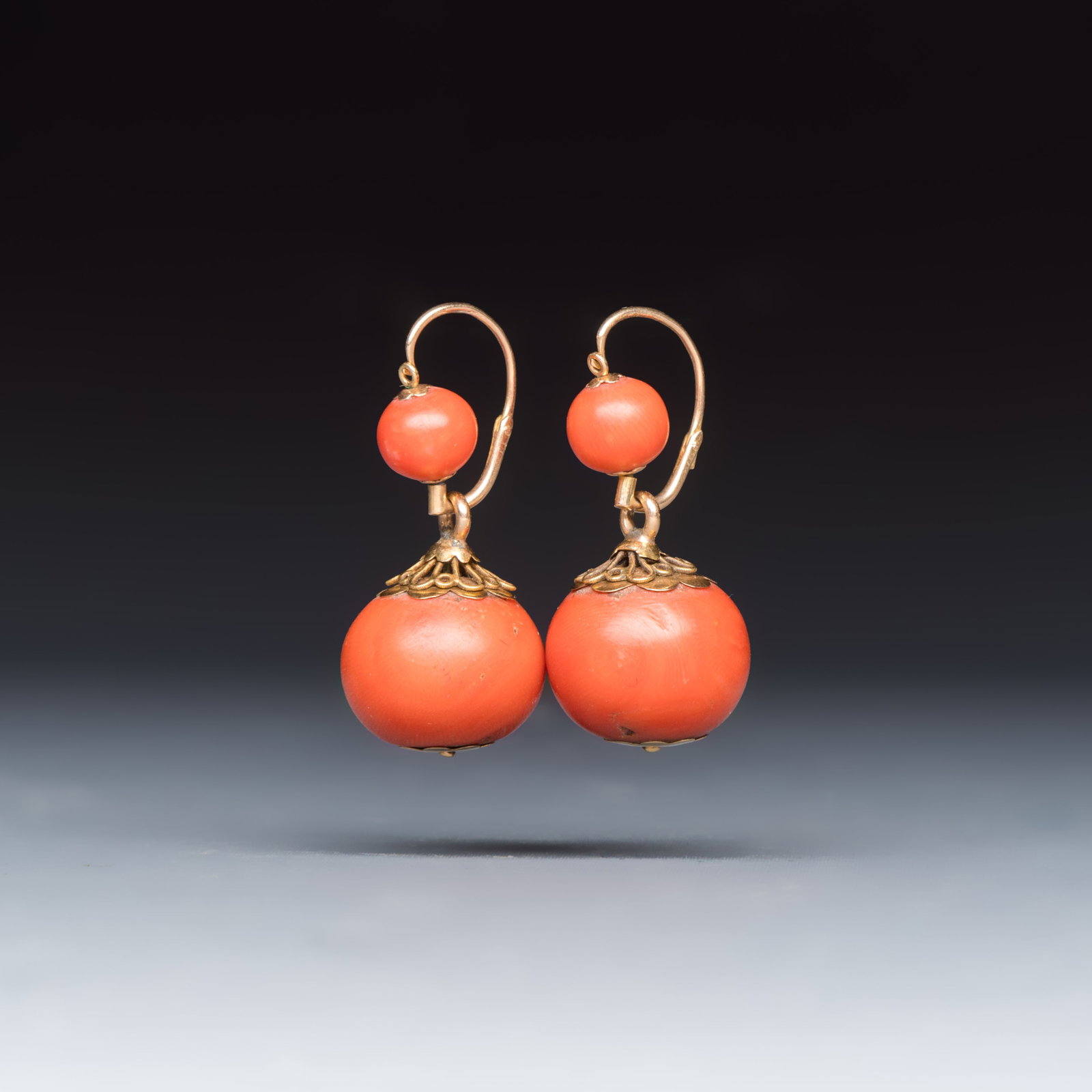 A pair of yellow gold and red coral dormeuse earrings, 20th C.: A pair of yellow gold and red coral dormeuse earrings, 20th C. Dim: 3,5 x 1,8 x 1,8 cm Total weight: 17 grams