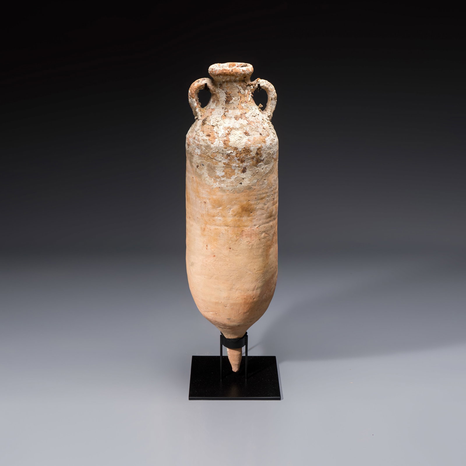 A large Roman pottery wine or fish oil transport amphora with marine encrustation, North Africa,: A large Roman pottery wine or fish oil transport amphora with marine encrustation, North Africa, 4/5th C. H.: 107 cm | incl. stand H.: 104,5 cm | excl. stand Provenance: Part of an important Belgian p