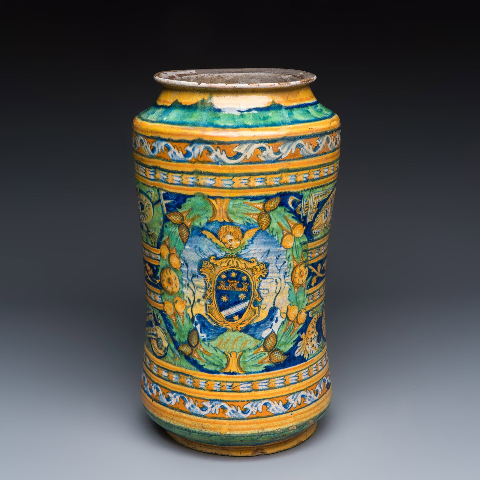 A large polychrome Italian maiolica albarello with a coat of arms beneath a cherub's head, 16th C.: A large polychrome Italian maiolica albarello with a coat of arms beneath a cherub's head, 16th C. H.: 39,5 cm