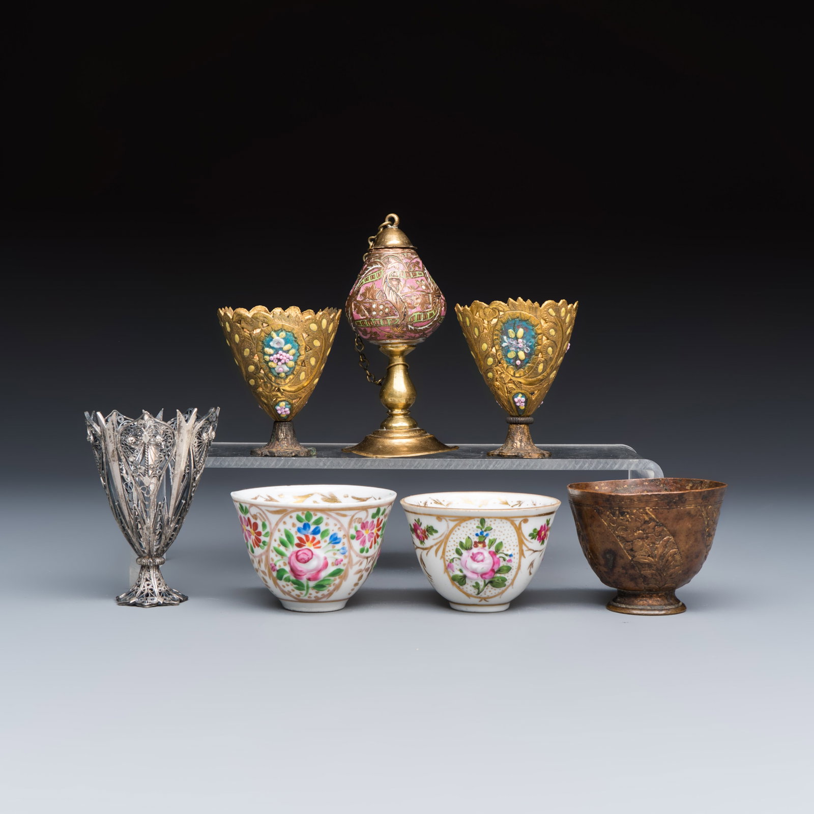 A group of four Ottoman zarfs, a scent burner and two porcelain tea bowls, Turkey, 18/19th C.: A group of four Ottoman zarfs, a scent burner and two porcelain tea bowls, Turkey, 18/19th C. H.: 8,5 cm | Weight: 72 grams (the gilt-copper enamelled scent burner) H.: 7 cm | Weight: 43 grams (the si