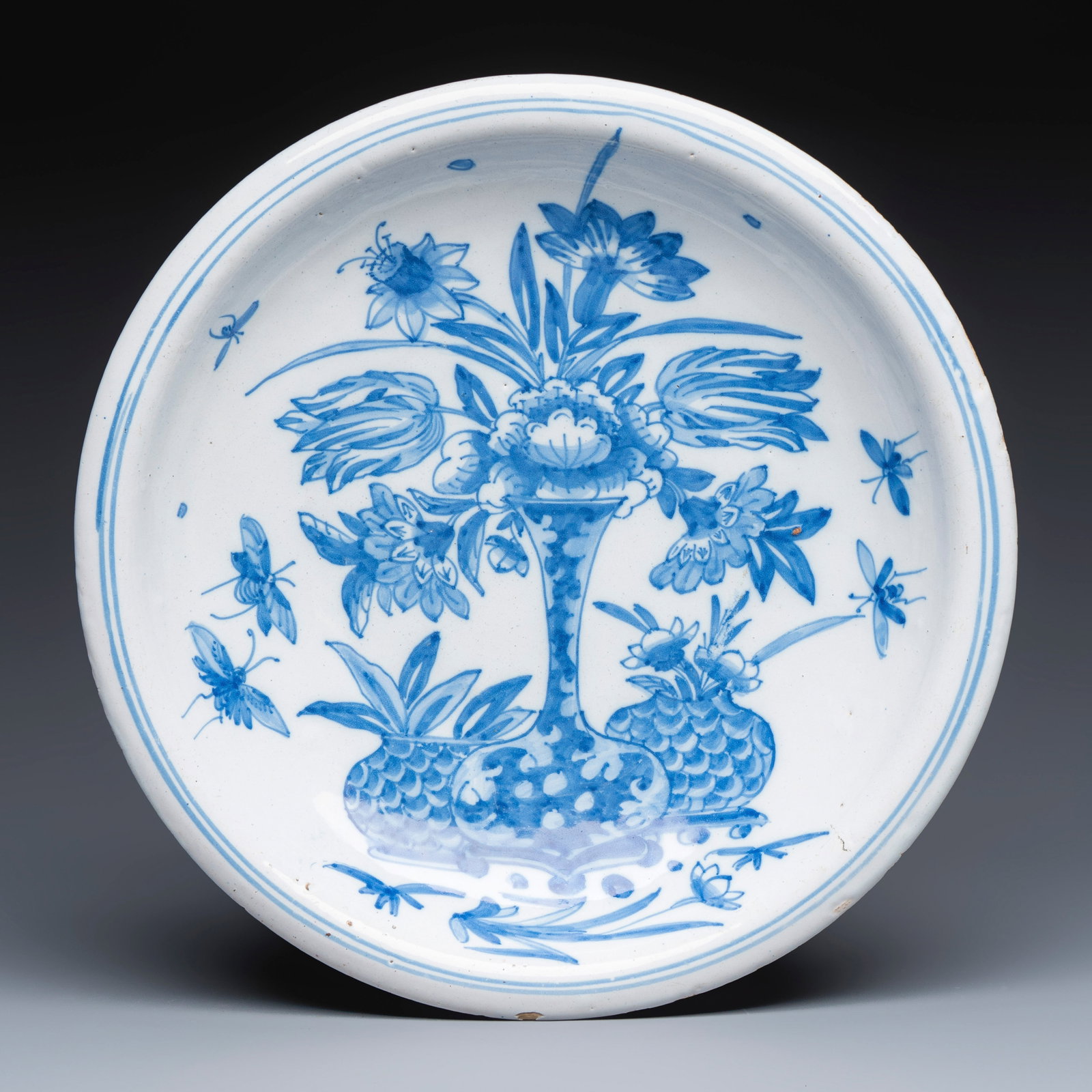 A blue and white Dutch Delft chinoiserie dish with flower vases and insects, 17th C.: A blue and white Dutch Delft chinoiserie dish with flower vases and insects, 17th C. Dia.: 33,4 cm