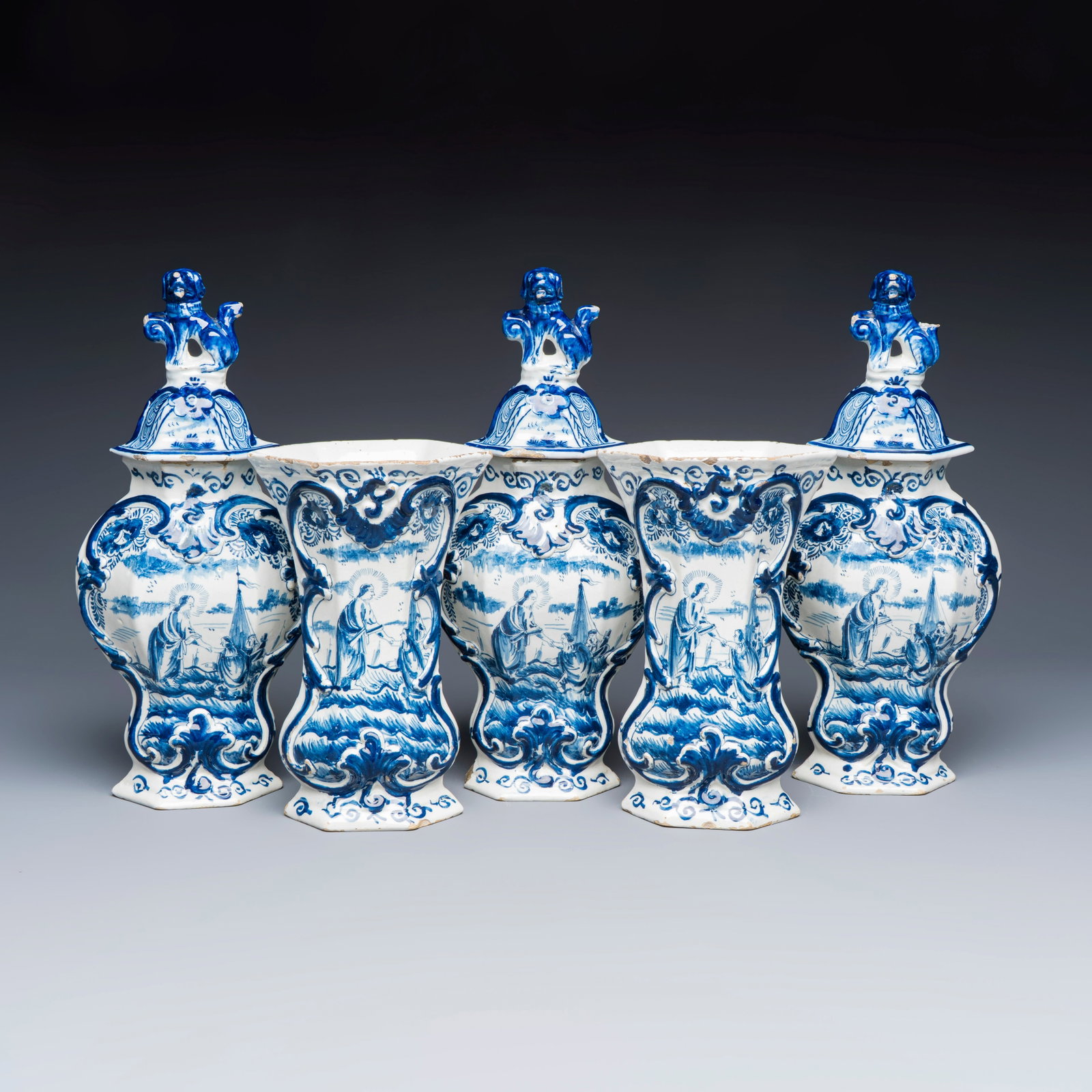 A blue and white Dutch Delft five-piece garniture, 18th C.: A blue and white Dutch Delft five-piece garniture, 18th C. H.: 35,5 cm | the tallest, incl. cover H.: 23,5 cm | the smallest beaker vase This garniture is spontaneously decorated with a scene from Mat