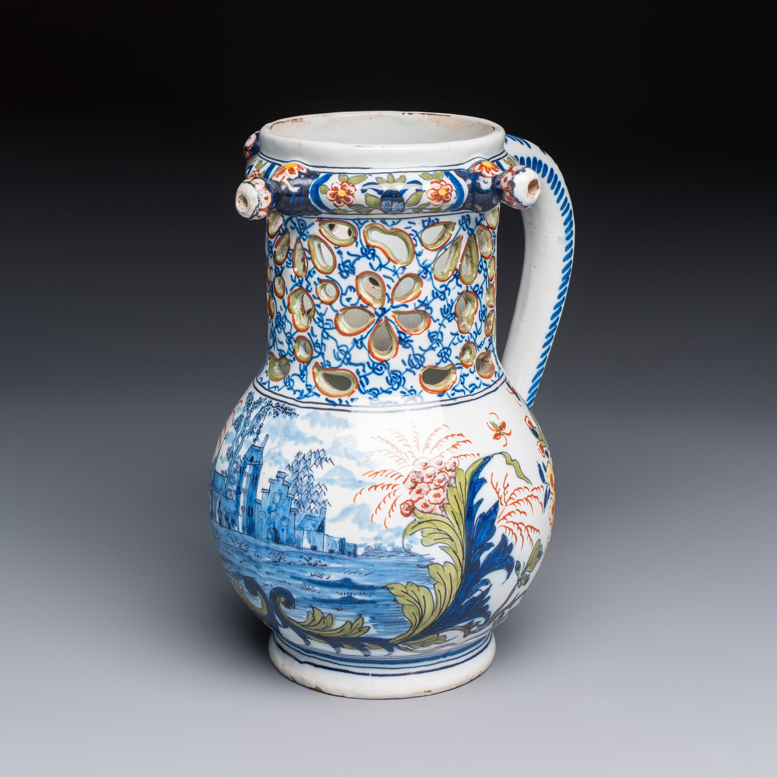 A polychrome Dutch Delft puzzle jug with a landscape scene, 19th C. (1 of 7)