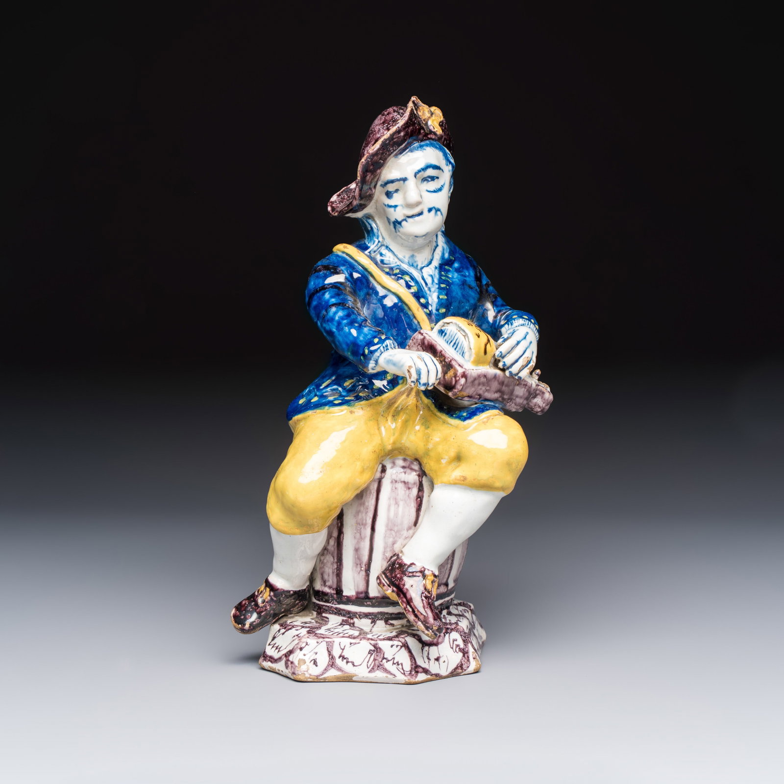 A polychrome Dutch Delft model of a hurdy-gurdy player, 18th C.: A polychrome Dutch Delft model of a hurdy-gurdy player, 18th C. H.: 26,9 cm