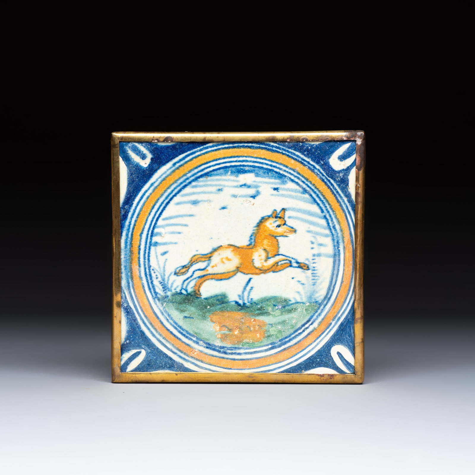 A polychrome Dutch Delft maiolica medallion tile with a leaping horse, 16th C. (1 of 2)
