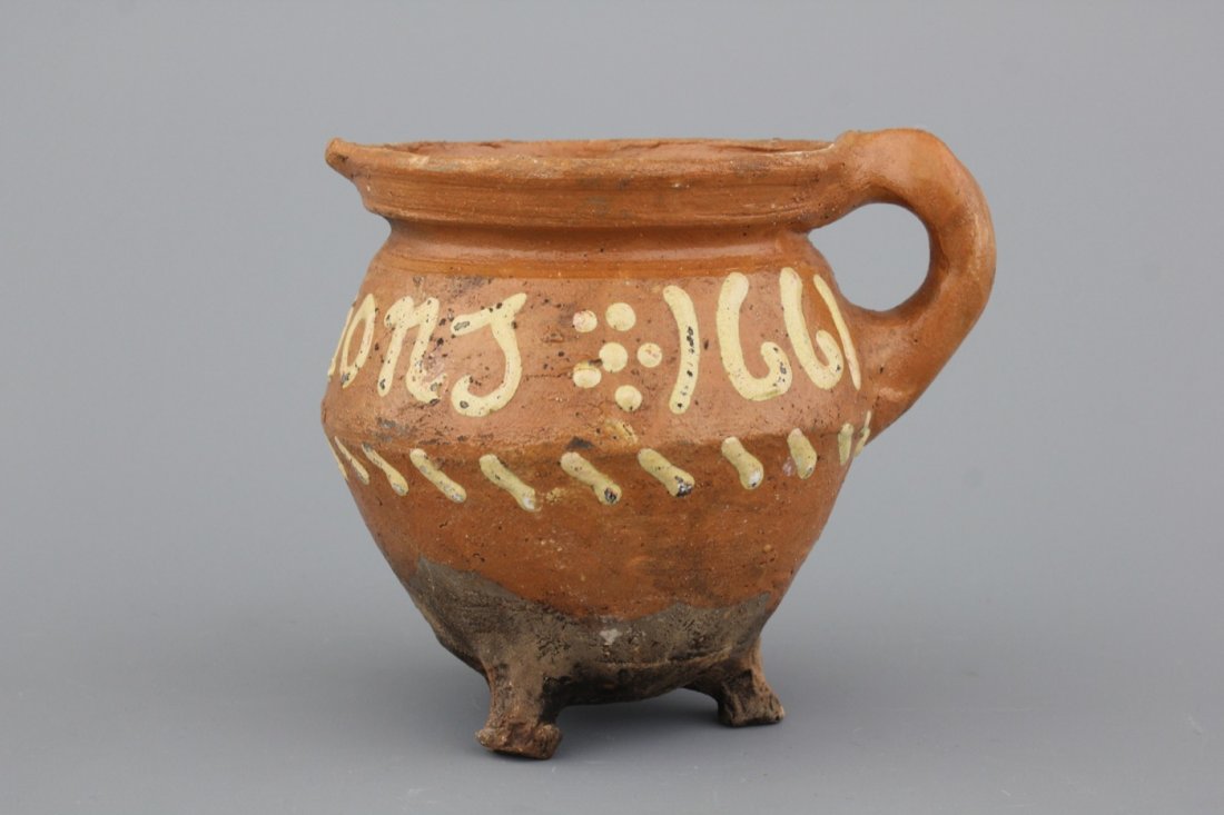A Dutch slipware chamber pot, dated 1661: Inscribed. H: 12,5 cm