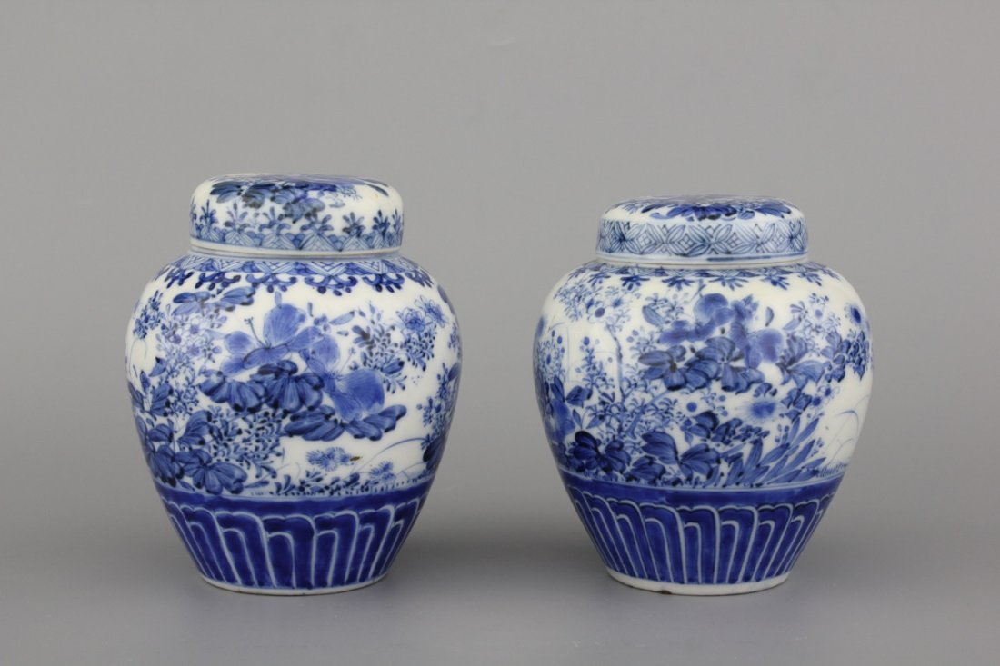 A pair of Japanese porcelain blue and white Arita jars: Condition: good. H: 14,5 and 13,5 cm.