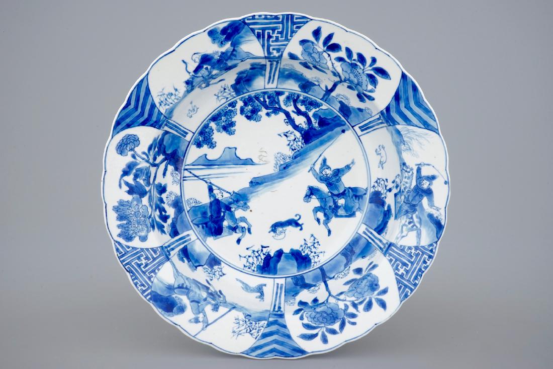 A deep Chinese blue and white plate with a battle scene: A deep Chinese blue and white plate with a battle scene on horseback, Kangxi Dia.: 27,5 cm - H.: 7 cm