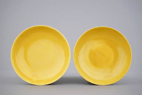 A pair of Chinese yellow glazed saucer dishes with: A pair of Chinese yellow glazed saucer dishes with incised backs, Qianlong sealmark and poss. of the period Dia.: 15,5 cm