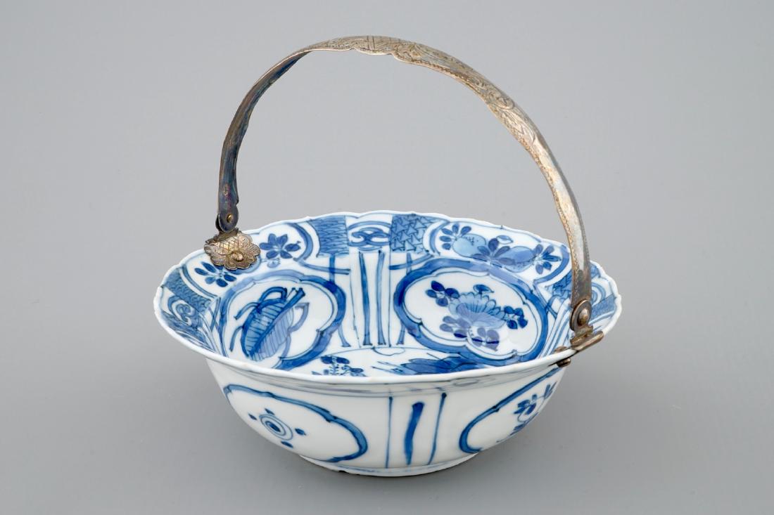 A Chinese blue and white silver-handled Kraak porcelain: A Chinese blue and white silver-handled Kraak porcelain klapmuts bowl with a salamander, Wanli, 1573-1619 Dia.: 14,3 cm - H.: 5 cm - H.: 12 cm (metal handle upright)