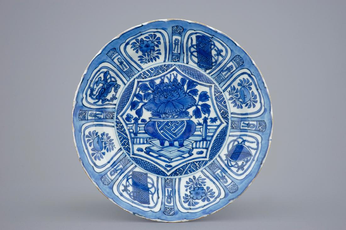 A blue and white Chinese kraak porcelain dish with a: A blue and white Chinese kraak porcelain dish with a flower vase, Wanli, 1573-1619 Dia.: 28,5 cm - H.: 5,5 cm