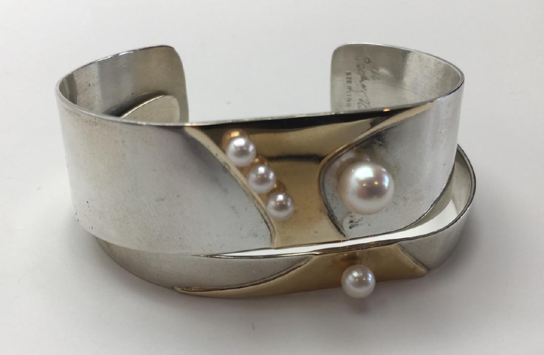 Betsy Fuller Modernist Bracelet Pair Sterling, 14K: A stunning pair of modernist sterling silver cuff bracelets overlaid with 14K gold and cultured pearls. Signed by the artist and marked sterling and 14K.