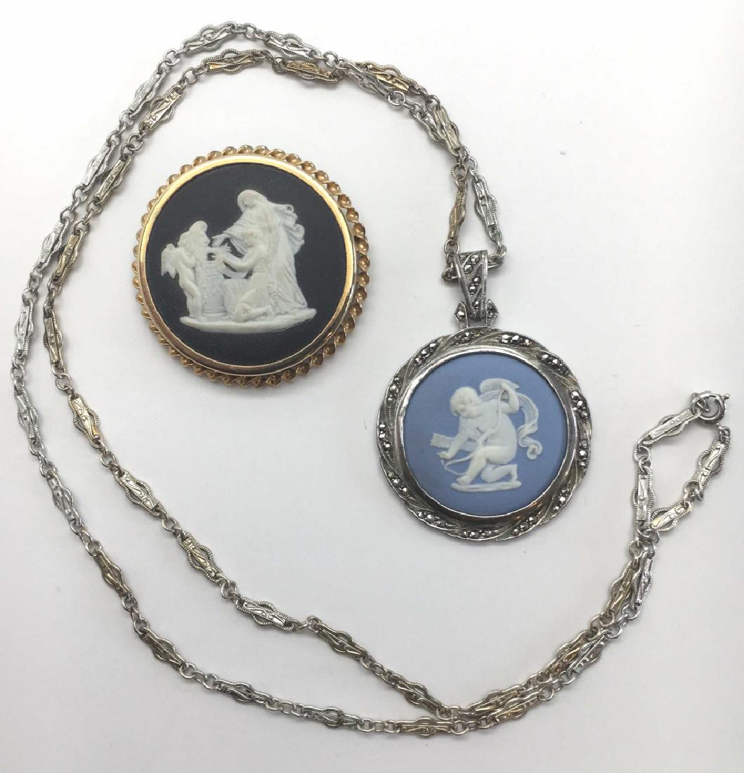 Lot of 2 Wedgwood Jasperware Cameo Pendants: The first is in black basalt, bezel set in a gold tone, it may be worn as a brooch or pendant. The second pendant is in Wedgwood's signature blue. Set in silver with marcasites, the chain measures 25 