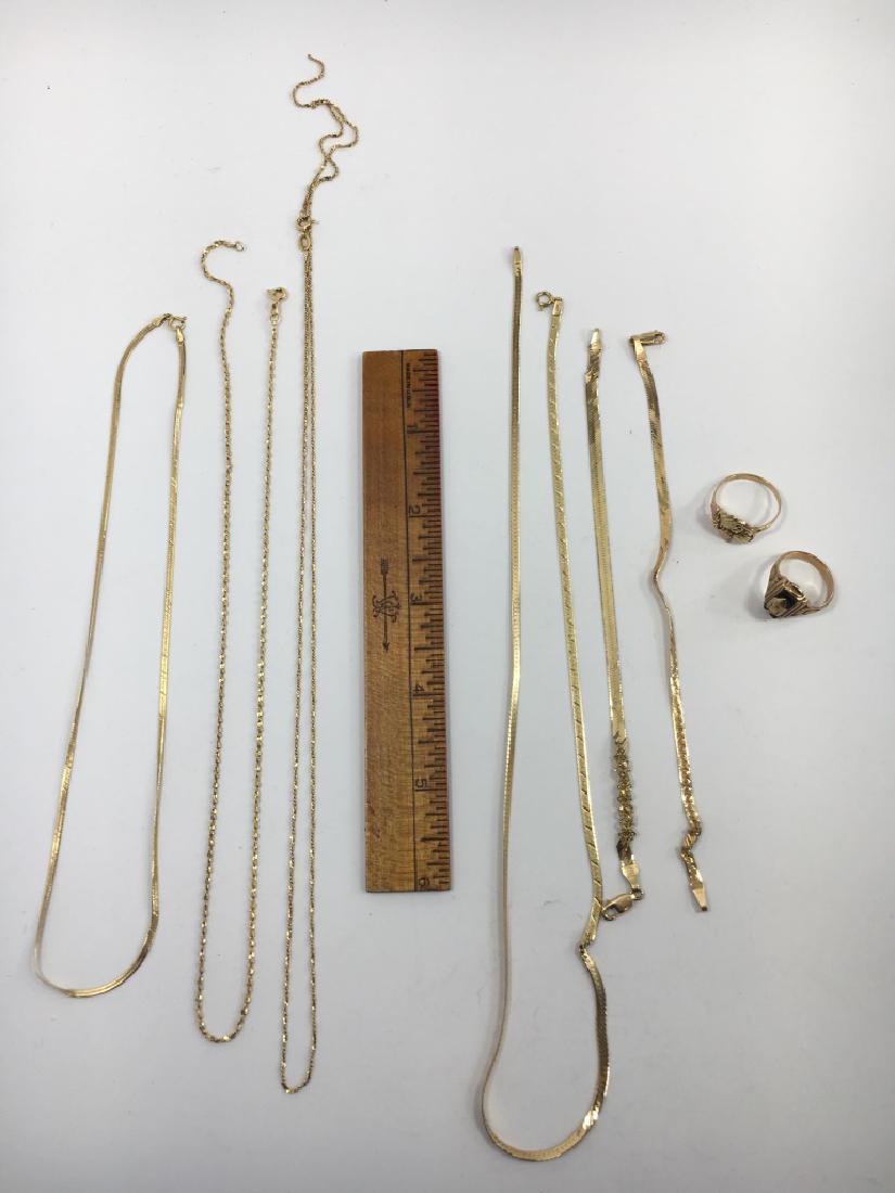 18K, 14K, 10K Mixed Scrap Gold Jewelry: The 3 chains to the left are 18K gold and together weigh approximately 9.1 grams. The chain and 2 bracelets in the center are 14K and together weigh approximately 10.6 grams. The 2 rings on the right
