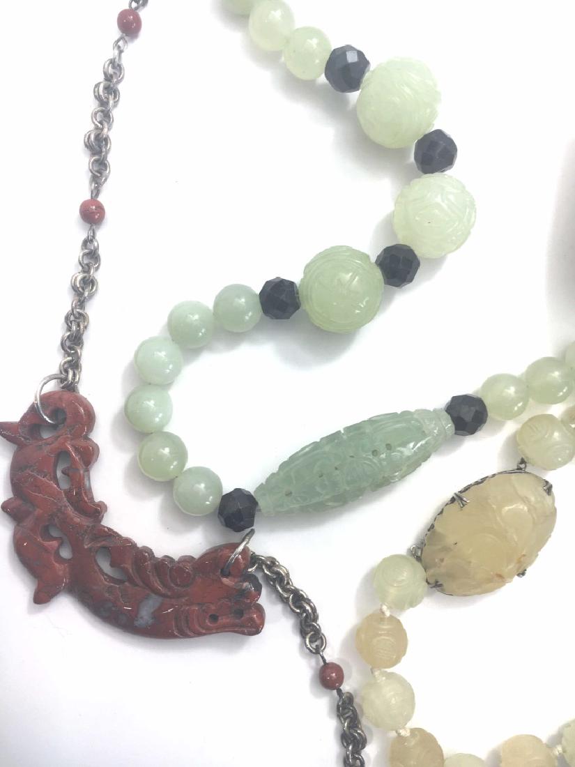 3 Vintage Asian Necklaces, Carved Jade, Sterling: The largest features green carved jade with faceted garnet spacers - 27" long. The smaller set of beads is in soft yellow hues with a large carved stone set in its sterling clasp - 18" long. Third is