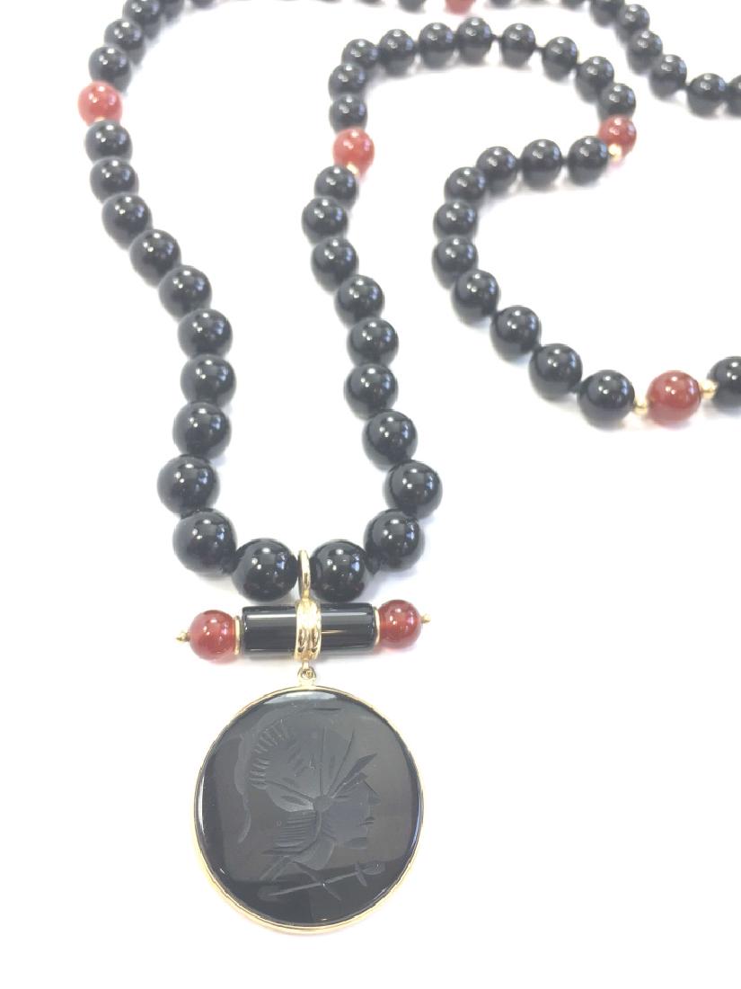 14K, Onyx and Carnelian Intaglio Necklace: A beautifully made piece in what appears to be onyx and carnelian. The beads are knotted. The gold is marked MB 14K. It is approximately 28" in length.