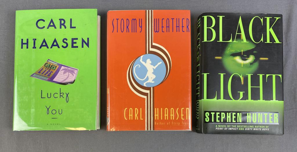3 Signed 1st Editions Carl Hiaasen, Stephen Hunter: Includes "Lucky You" by Carl Hiaasen 1997 - signed 1st edition, "Stormy Weather" also by Hiaasen 1995 - signed first edition and "Black Light" by Stephen Hunter 1996 - signed first edition. Condition 