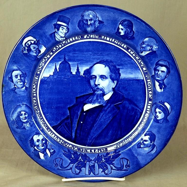 C/1900 Royal Doulton Flo-Blue Charles Dicken Plate: C/1900 Flo-Blue Charles Dickens Plate By Royal Doulton With Various Dickens Characters Around The Rim, 10 ½” Dia. SHIPPING: Shipping Handled In-House by Epic
