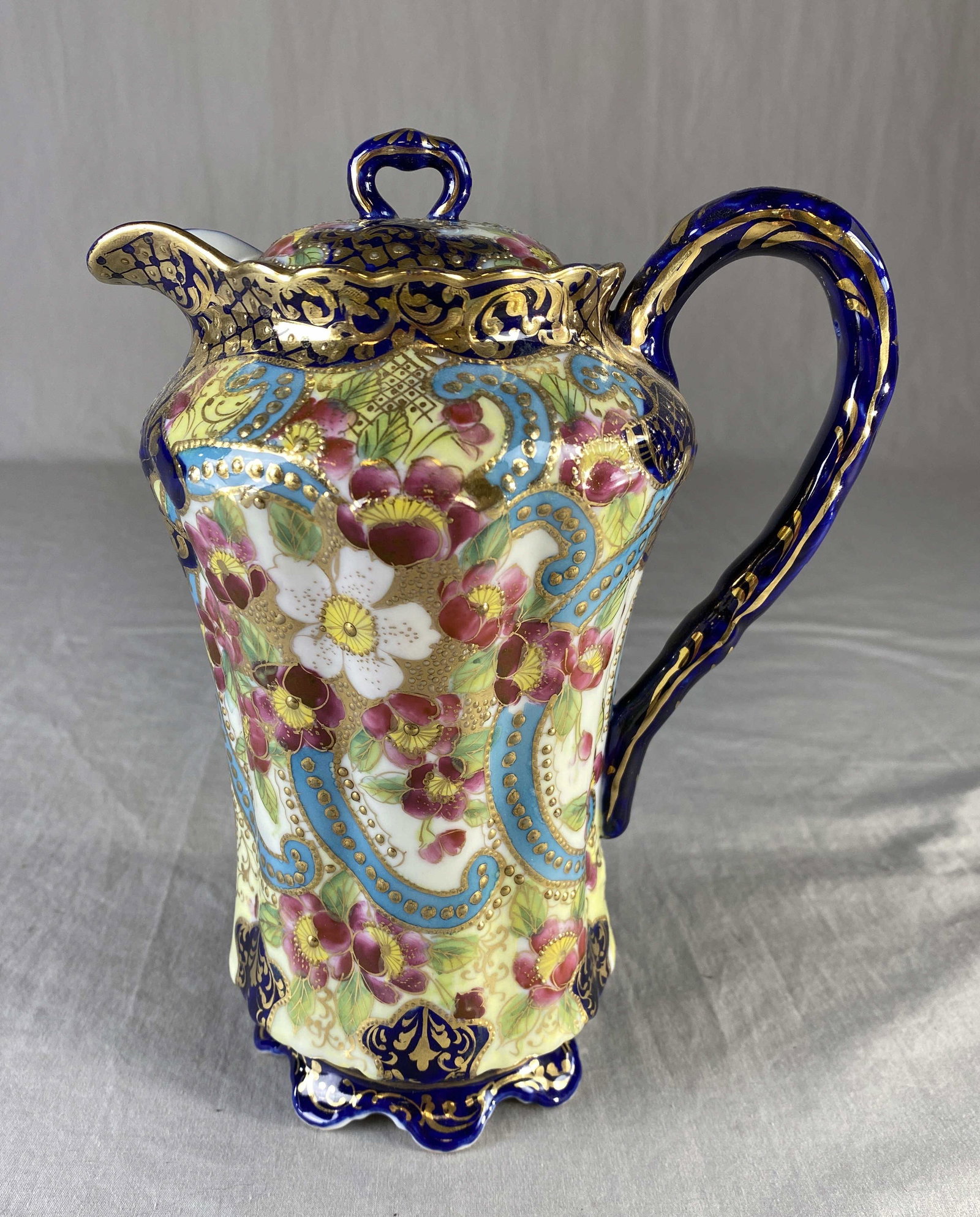 Ornate Hand Painted Nippon Chocolate Pot: A lovely Nippon chocolate pot ornamented with hand painted blossoms and cobalt and gold trim. It measures 9 1/4" tall.