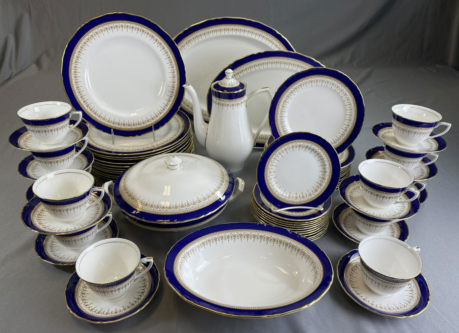 Royal Worcester Regency Dinner Service for 12: A fine bone china dinnerware set for 12 in the Regency pattern by Royal Worcester in cobalt blue on white with gold decoration. Includes: (12) 10 7/8" dinner plates, (12) 8" salad plates, (12) 6 1/8"