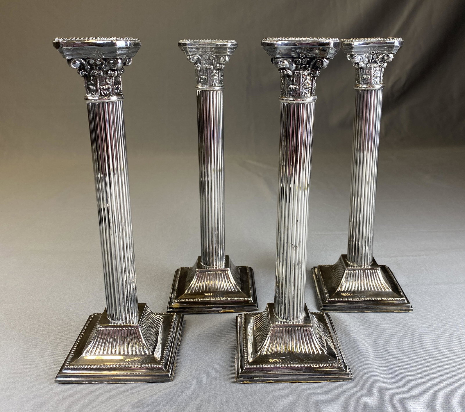 4 Silverplate Corinthian Column Candlesticks: From F. B. Rogers, a set of four matching silver plated column form candlesticks. Each measures 10 1/8" tall.