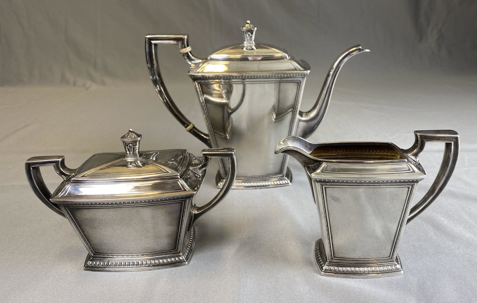 Pantheon Sterling Tea Set Alfred G. Kintz C.1920: An art deco era 1920s Federal style heavy sterling silver three piece tea set in the "Pantheon" pattern. Designed by Alfred G. Kintz in 1920 for International Silver Co. Includes an 8 1/2" tall teapot