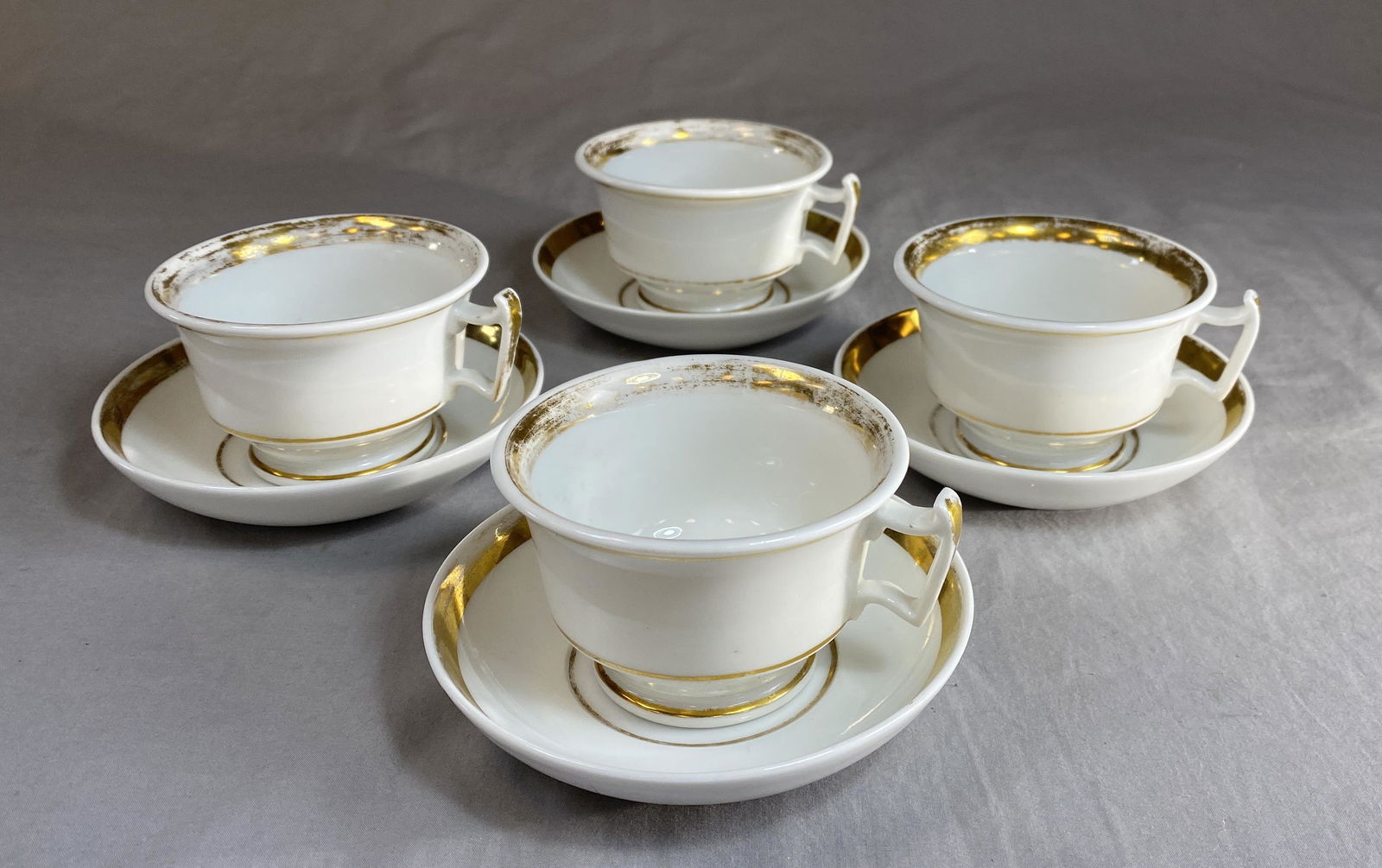 Four 19th C. Old Paris Porcelain Cup & Saucer Sets: Gilt edged 19th century French porcelain cups with deep saucers and wishbone handles.