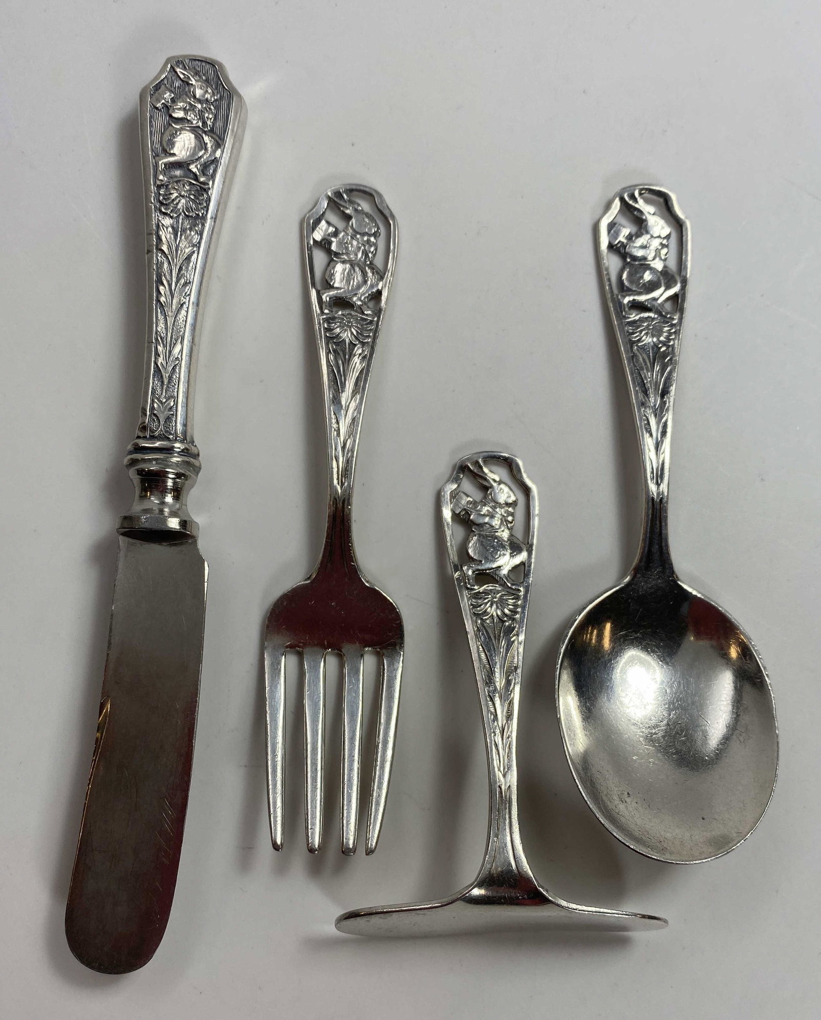 Webster Sterling Peter Rabbit 4 pc. Nursery Set: A four piece sterling children's flatware set from Webster in the Peter Rabbit pattern. It includes a knife, a spoon, a fork and a food pusher. Marked as shown. Total weight for the set is 56 grams.